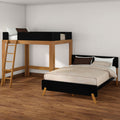 Modern wooden loft bed with ladder above a black-accented platform bed, beige bedding and pillows in a minimalist bedroom with hardwood floors
