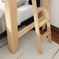 Light natural wood loft bed ladder beside bunk mattress on beige rug and hardwood floor in a modern kids' bedroom
