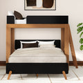 Modern wooden full-over-twin bunk bed with black accents, neutral beige bedding, ladder and houseplant in a contemporary space-saving bedroom designed for kids or guests