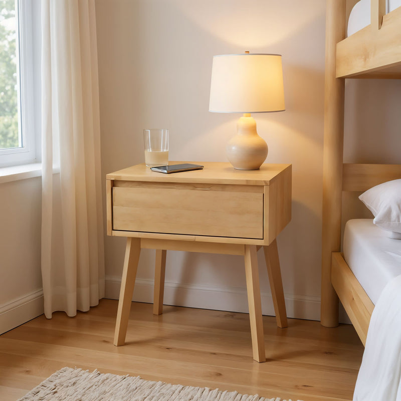 Modern wooden nightstand with table lamp, glass, and tablet in cozy bedroom.