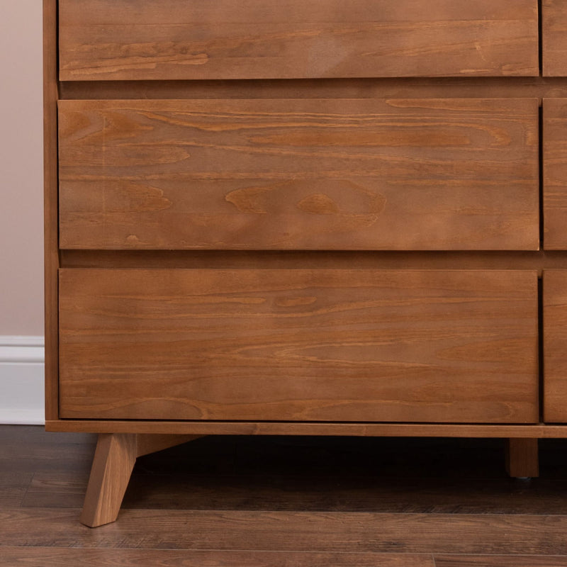 Close-up of mid-century modern solid wood dresser drawers with walnut finish and angled legs on hardwood floor, minimalist bedroom furniture