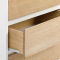 Open wooden drawer of a modern light wood dresser with smooth finish and minimalist design.