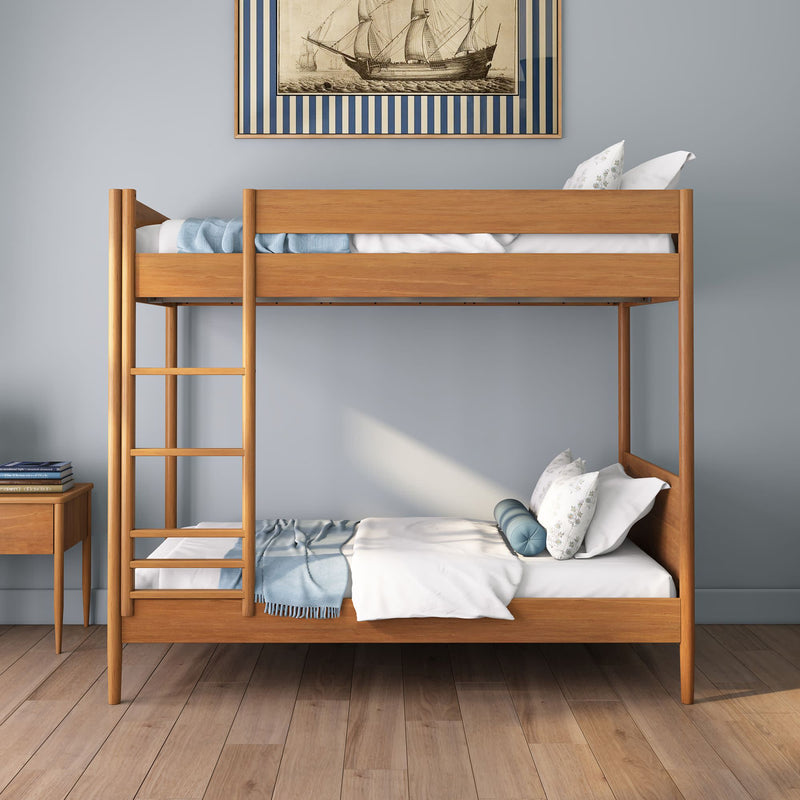 Modern solid wood bunk bed with ladder, blue and white bedding and decorative pillows in a minimalist coastal-style bedroom