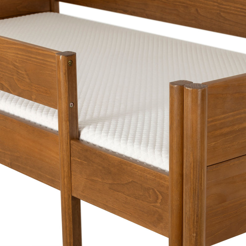 Close-up of solid wood twin bed frame with warm natural finish and textured white mattress