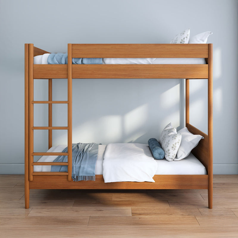 Modern solid wood twin-over-twin bunk bed with ladder in a minimalist kids' bedroom, white bedding and blue throw on hardwood floor