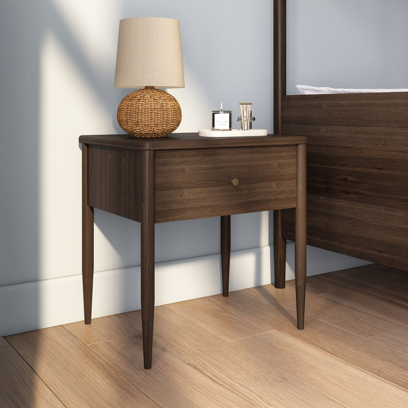 Mid-century modern walnut nightstand bedside table with single drawer, wicker lamp and decorative tray on hardwood bedroom floor