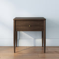 Mid-century modern walnut nightstand - wooden bedside table with single drawer, brass knob and tapered legs on hardwood floor