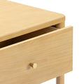 Minimalist light wood nightstand with partially open drawer, rounded top edge and brass knob