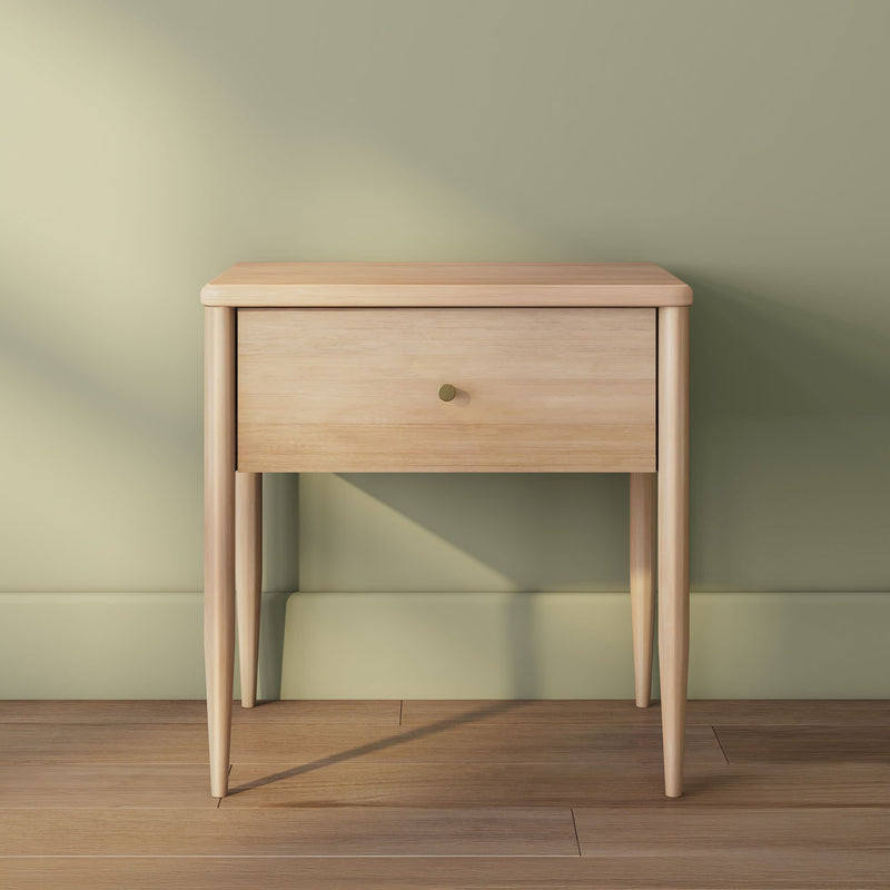 Minimalist light oak solid wood nightstand with single drawer and brass knob, tapered legs — mid-century modern bedside table against sage green wall on hardwood floor