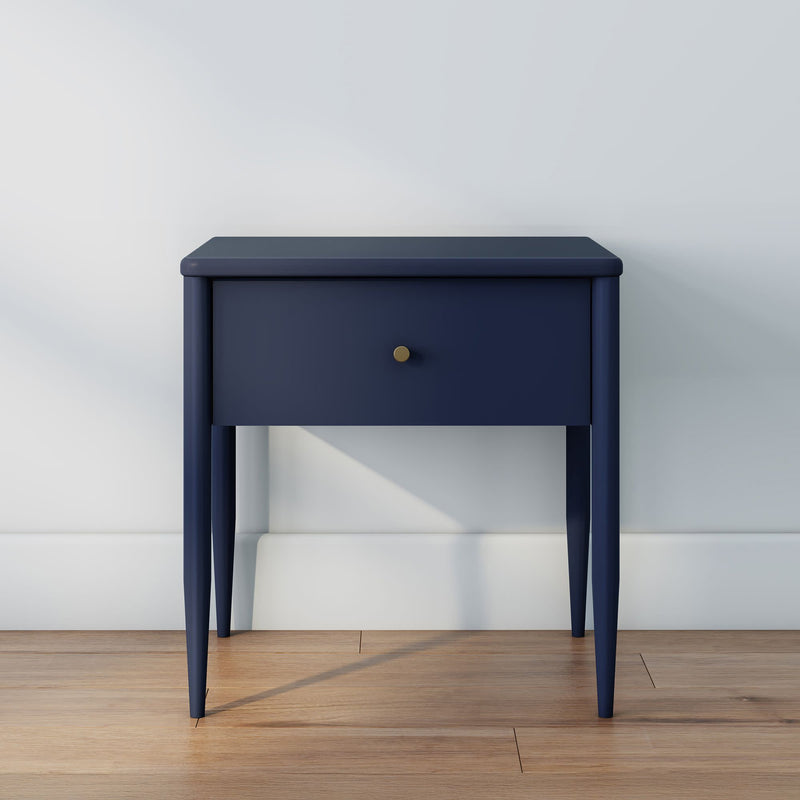Navy blue modern bedside table with single drawer and brass knob on hardwood floor