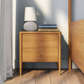 Mid-century modern wooden nightstand with two drawers, textured table lamp and stacked design books on hardwood floor in a minimalist bedroom interior