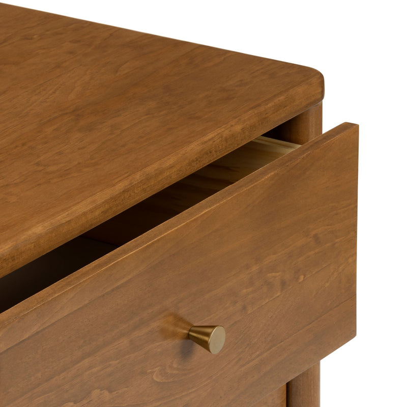 Close-up of honey brown solid wood dresser drawer with brass knob, partially open mid-century modern nightstand detail