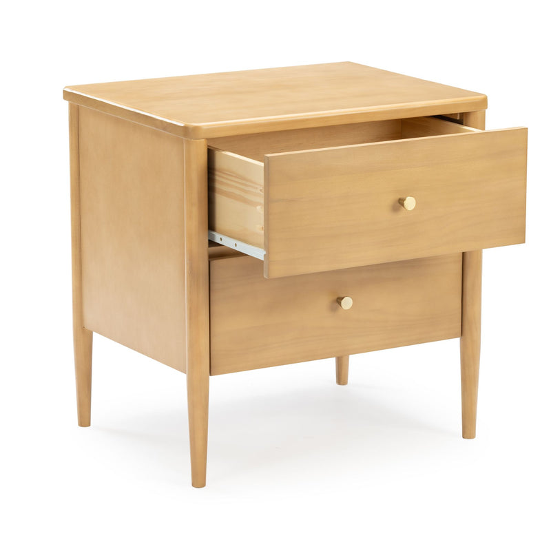 Mid-century modern light wood bedside nightstand with open top drawer, round brass knobs and tapered legs on white background