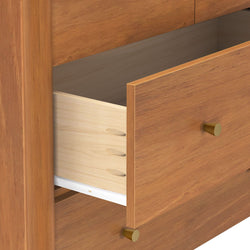 Close-up of open wooden dresser drawer with dovetail joints, light maple drawer box, brass knobs and white drawer slide, mid-century modern furniture