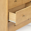 Close-up of an open light pine dresser drawer with brass knob, visible dovetail joints and metal slide — wooden dresser bedroom storage detail