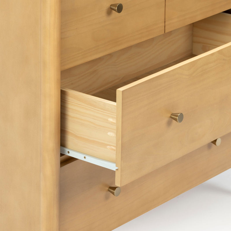 Close-up of an open light pine dresser drawer with brass knob, visible dovetail joints and metal slide — wooden dresser bedroom storage detail