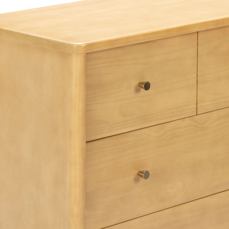 Close-up of light maple wood dresser with rounded top edge, drawers and brass cone knob — modern minimalist bedroom storage