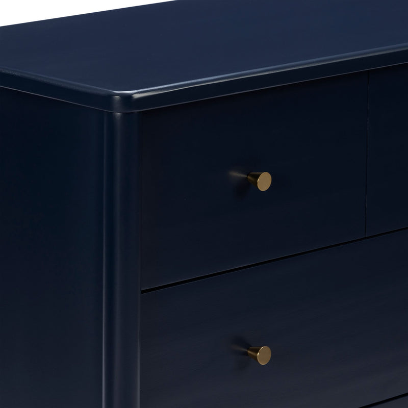 Close-up of navy blue dresser drawer with brass knob, modern matte-finish nightstand for bedroom storage