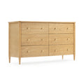 Mid-century modern light natural wood six-drawer dresser with round brass knobs and tapered legs on white background
