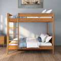 Modern natural wood bunk bed (twin over twin) in a minimalist kids bedroom with blue throw blanket, decorative pillows, hardwood floor and nautical ship wall art