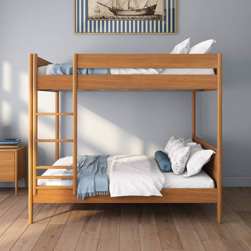 Modern natural wood bunk bed (twin over twin) in a minimalist kids bedroom with blue throw blanket, decorative pillows, hardwood floor and nautical ship wall art