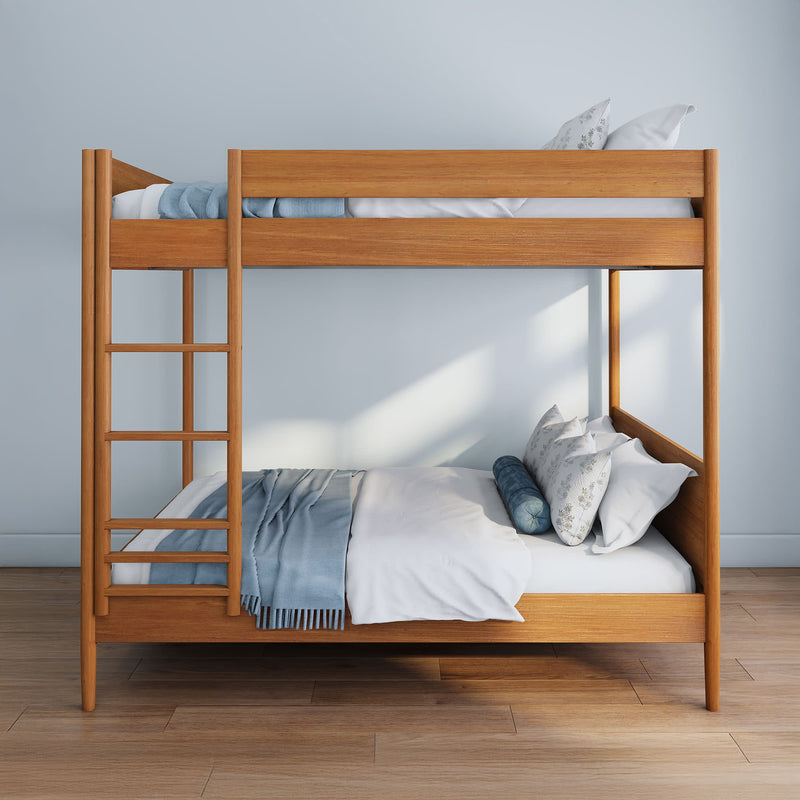 Modern wooden bunk bed with ladder, blue throw and white pillows in a minimalist bedroom on hardwood floor