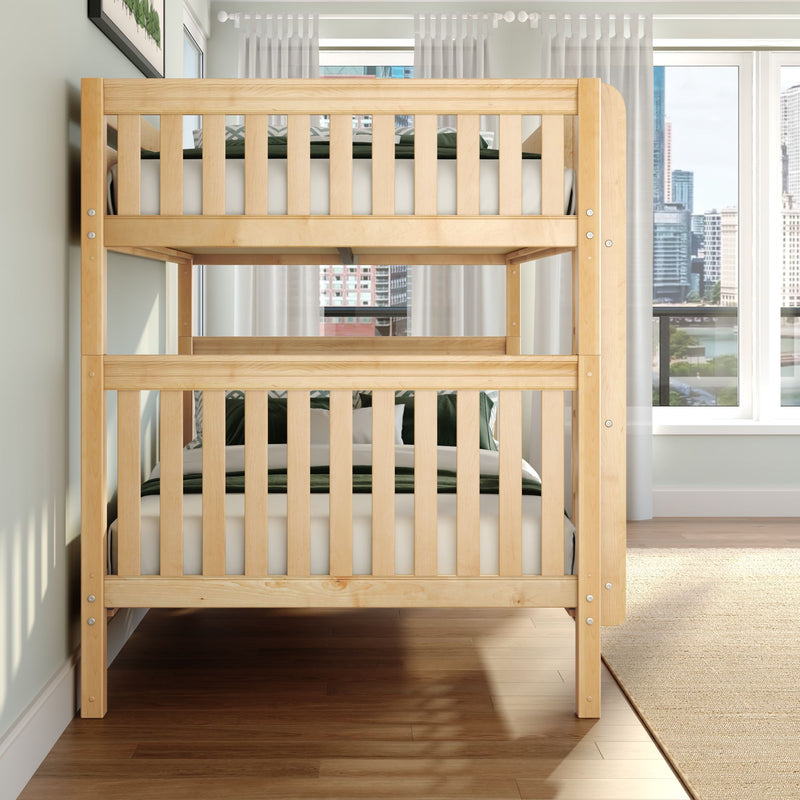Solid natural wood twin-over-twin bunk bed with slatted rails and green bedding in a bright, space-saving kids' bedroom with city-view windows