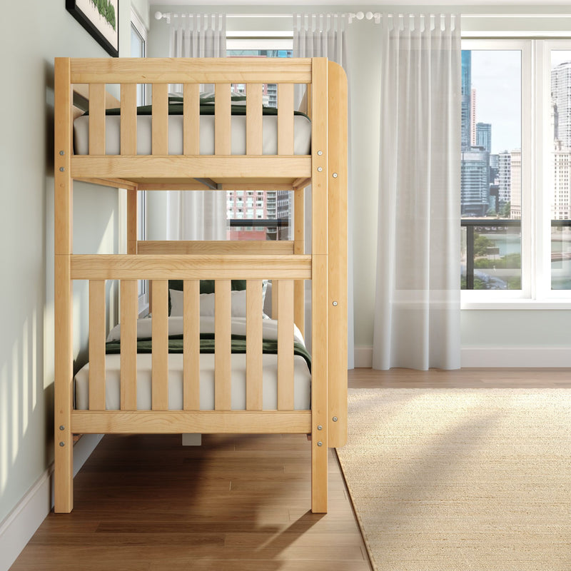 Natural wood twin bunk bed in a bright modern bedroom with sheer curtains, hardwood floors and a city skyline view