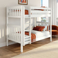 Modern white wooden bunk bed with ladder and safety rails, rust-orange bedding and pillows in a bright city apartment bedroom