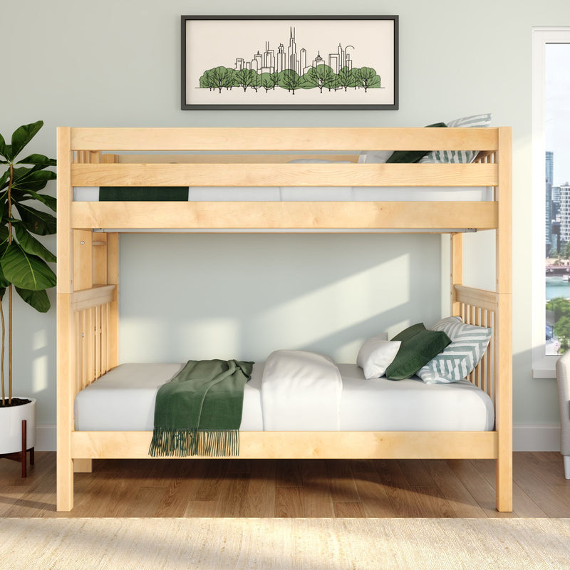 Natural wood bunk bed in a sunlit modern bedroom with white bedding, green throw and striped pillows, framed city skyline art and a fiddle leaf fig plant