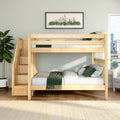 Light wood bunk bed with built-in storage stairs in a modern kids' bedroom, green bedding, framed cityscape wall art and potted plant