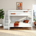 White loft bunk bed with built-in storage stairs in a bright modern kids' bedroom, orange throw and pillows, framed autumn cityscape artwork, potted plant and window with city skyline view