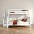 White wooden bunk bed with staircase storage and orange throw and pillows in a modern neutral children's bedroom with hardwood floor