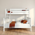 White wooden bunk bed with ladder, cozy orange throw pillows and blanket, minimalist kids bedroom bathed in natural light on hardwood floor