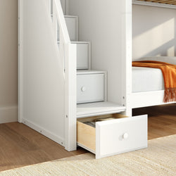 White wooden bunk bed with built-in stair drawers and orange throw in modern kids' room, space-saving storage solution