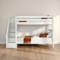 Modern white wooden bunk bed with staircase storage drawers, orange pillows and throw in a kids bedroom with beige walls and light wood floor