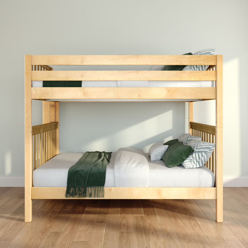 Light wood bunk bed with white bedding, green throw and patterned pillows on hardwood floor in a minimalist bedroom
