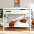 White wooden bunk bed in modern bedroom with orange throw and pillows, potted fiddle-leaf fig, framed autumn cityscape art, hardwood floors and city skyline view