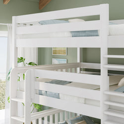 White wooden triple bunk bed with ladder in bright coastal kids bedroom, green accent wall, blue-gray bedding and indoor plant