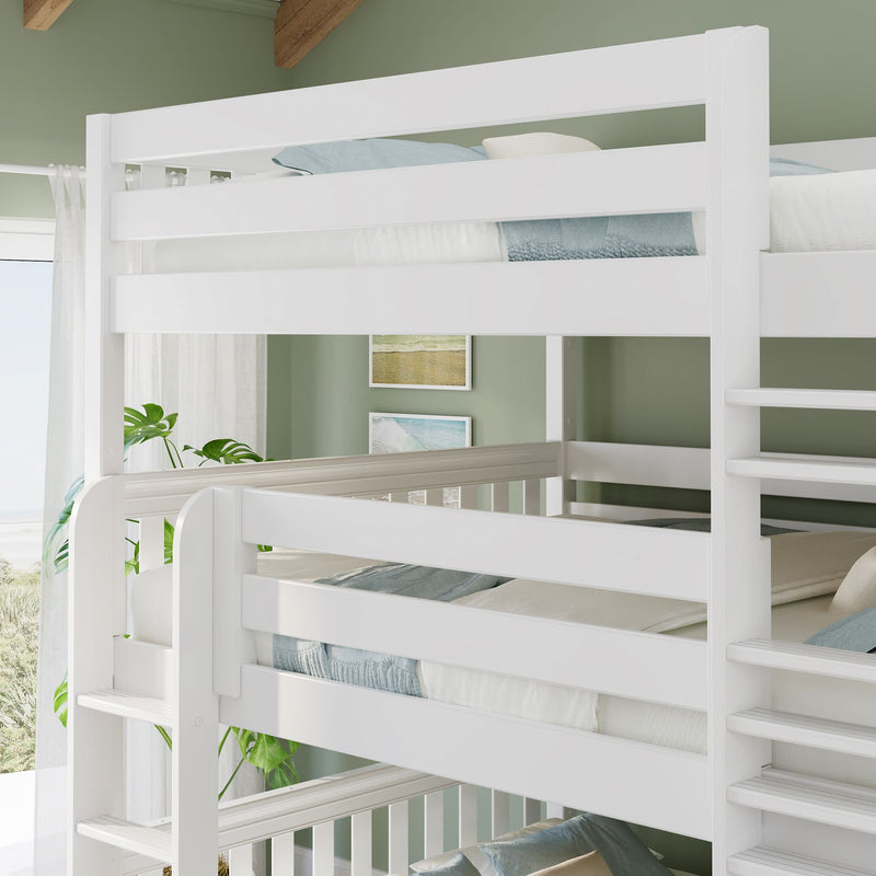 White wooden triple bunk bed with ladder in bright coastal kids bedroom, green accent wall, blue-gray bedding and indoor plant