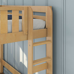 Close-up of a natural wood bunk bed ladder and safety rail on a children's loft bed with white knit bedding and navy throw against a blue paneled wall