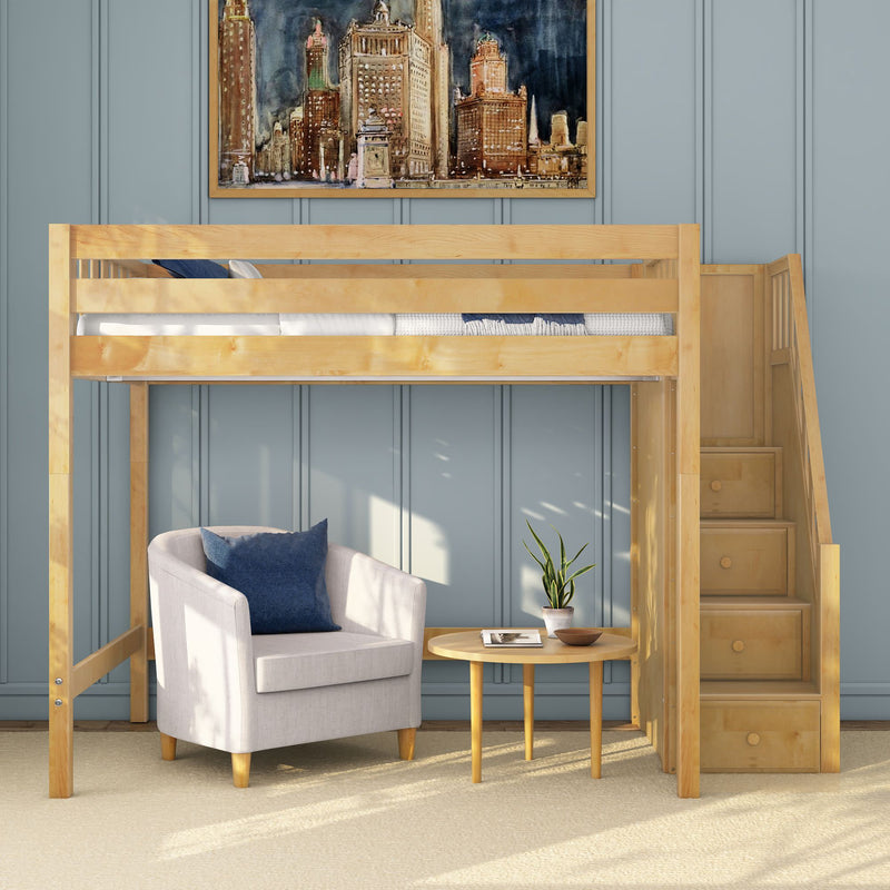 Wooden loft bed with built-in staircase over a cozy gray armchair and round side table with potted plant against blue paneled wall, modern kids' bedroom reading nook