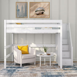 White wooden loft bed with built-in staircase above a cozy reading nook: beige armchair with yellow pillow, round side table with potted plant on blue-beige area rug