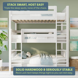 White solid hardwood space-saving triple bunk bed with ladders and guardrails, Rock Lock stability system, styled in a coastal green kids' room with beach wall art