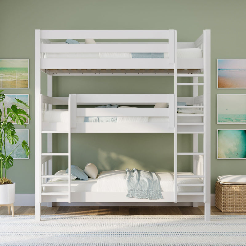 White wooden triple bunk bed in a bright kids' bedroom with green accent wall, coastal wall art, ladder, potted plant and woven storage basket