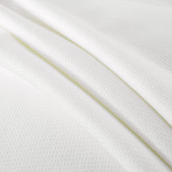 White waffle knit fabric close-up showcasing texture and pattern ideal for fashion and home textiles.