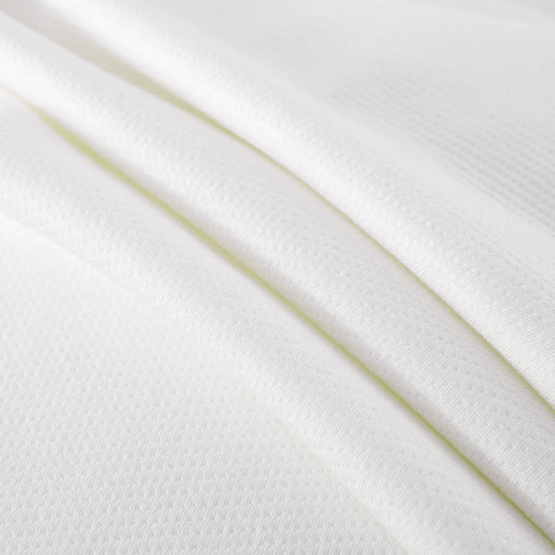 White waffle knit fabric close-up showcasing texture and pattern ideal for fashion and home textiles.