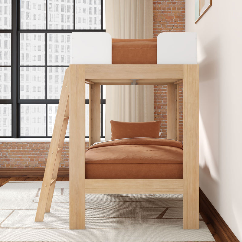 Modern natural wood loft bunk bed with rust-orange bedding in industrial loft bedroom with exposed brick wall, large grid windows and neutral rug