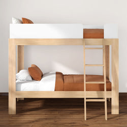 Modern natural wood twin-over-twin bunk bed with ladder, white and rust-orange bedding in a minimalist kids' bedroom on hardwood floor