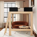 Wooden loft bed with ladder over cozy brown loveseat and round coffee table in a modern industrial small-apartment bedroom with exposed brick wall and large grid window